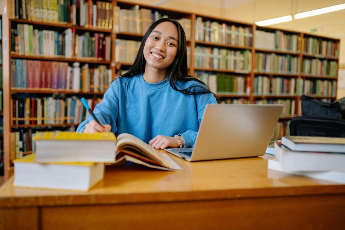 Estudante com computador na bliblioteca